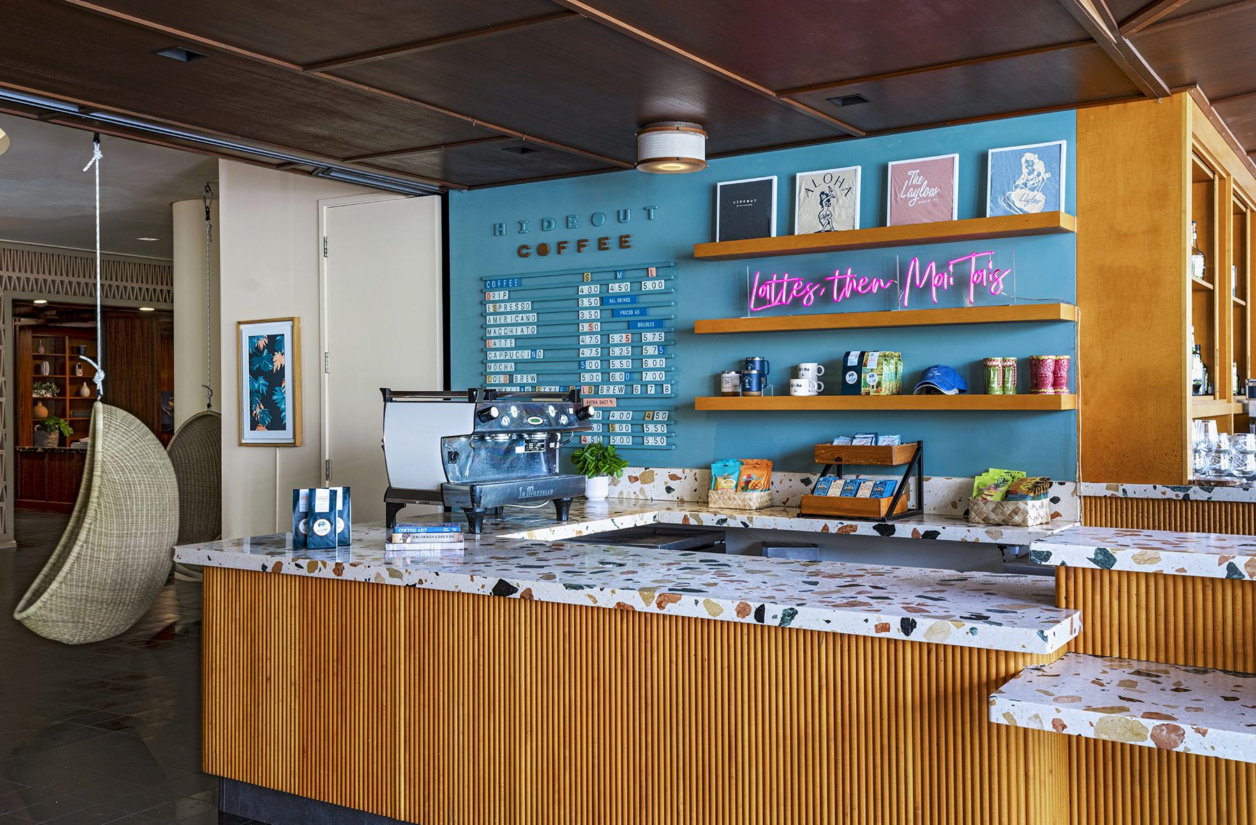 A cozy coffee shop interior with a colorful menu on the wall, vibrant decor, and barista equipment on the counter.